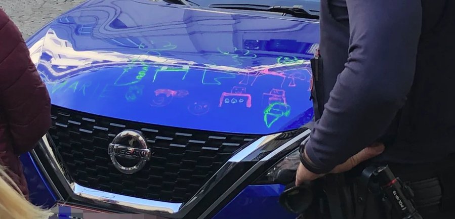 Kleines Mädchen bemalte blaues Auto in der Wiener City