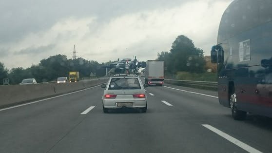 Suzuki-Lenker fährt mit Motorrad am Dach über Autobahn